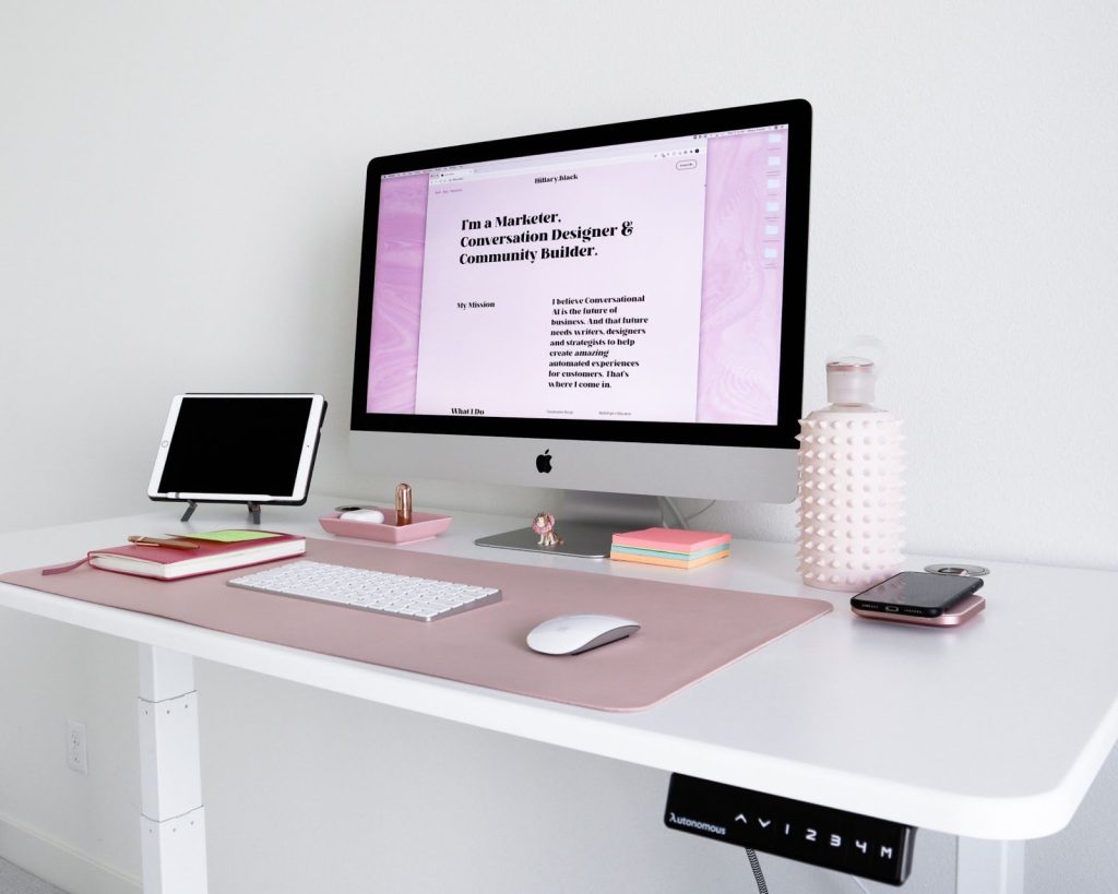 <tablet, computer, water bottle, and accessories on a motorised standing desk>