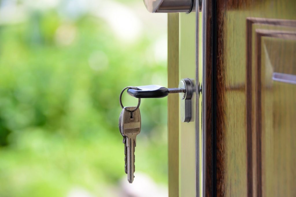 <key in the lock of a front brown front door>