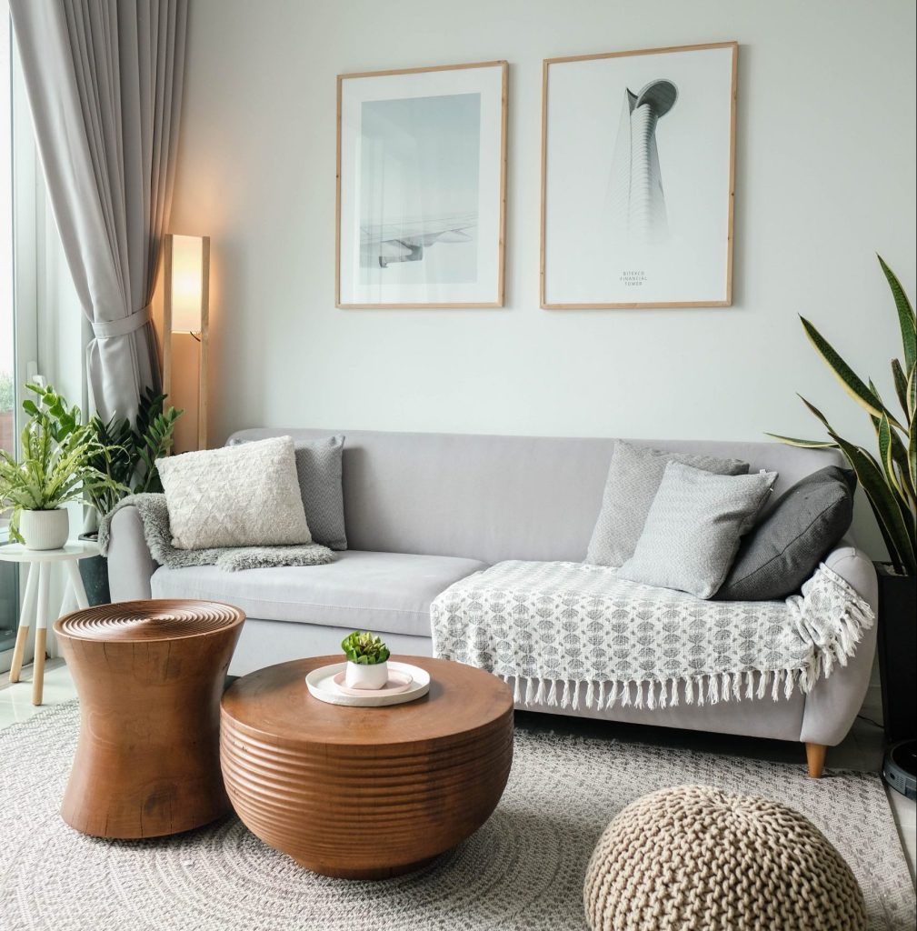 (alt-text: A living room with a gray couch and a bronze coffee table shows what it means to live a minimalist lifestyle.)